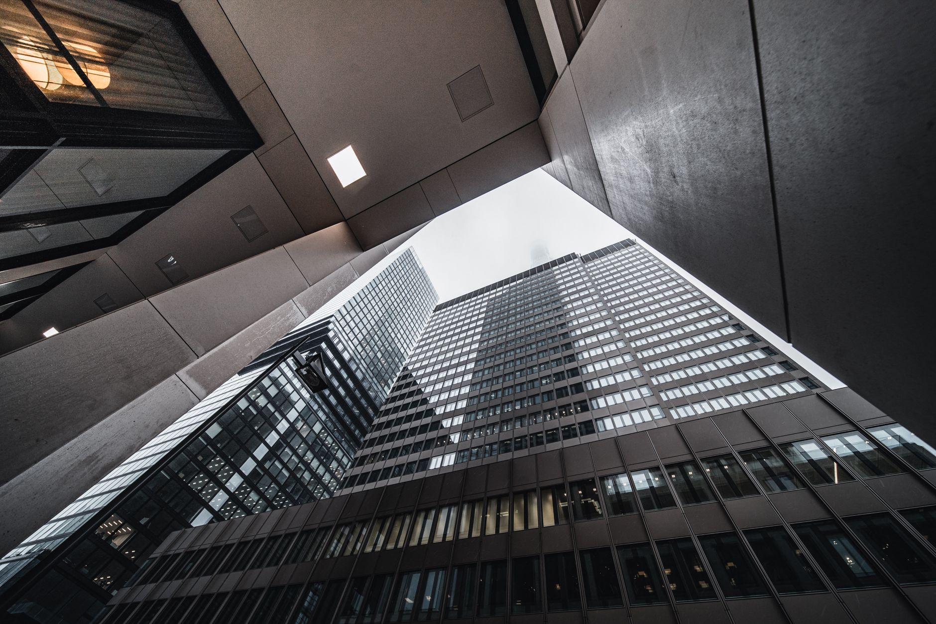 Low-angle view of modern skyscrapers with glass facades in an urban environment.