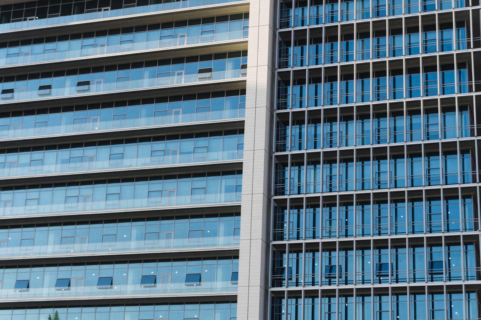 Detailed view of a modern highrise office building with glass windows and reflections.