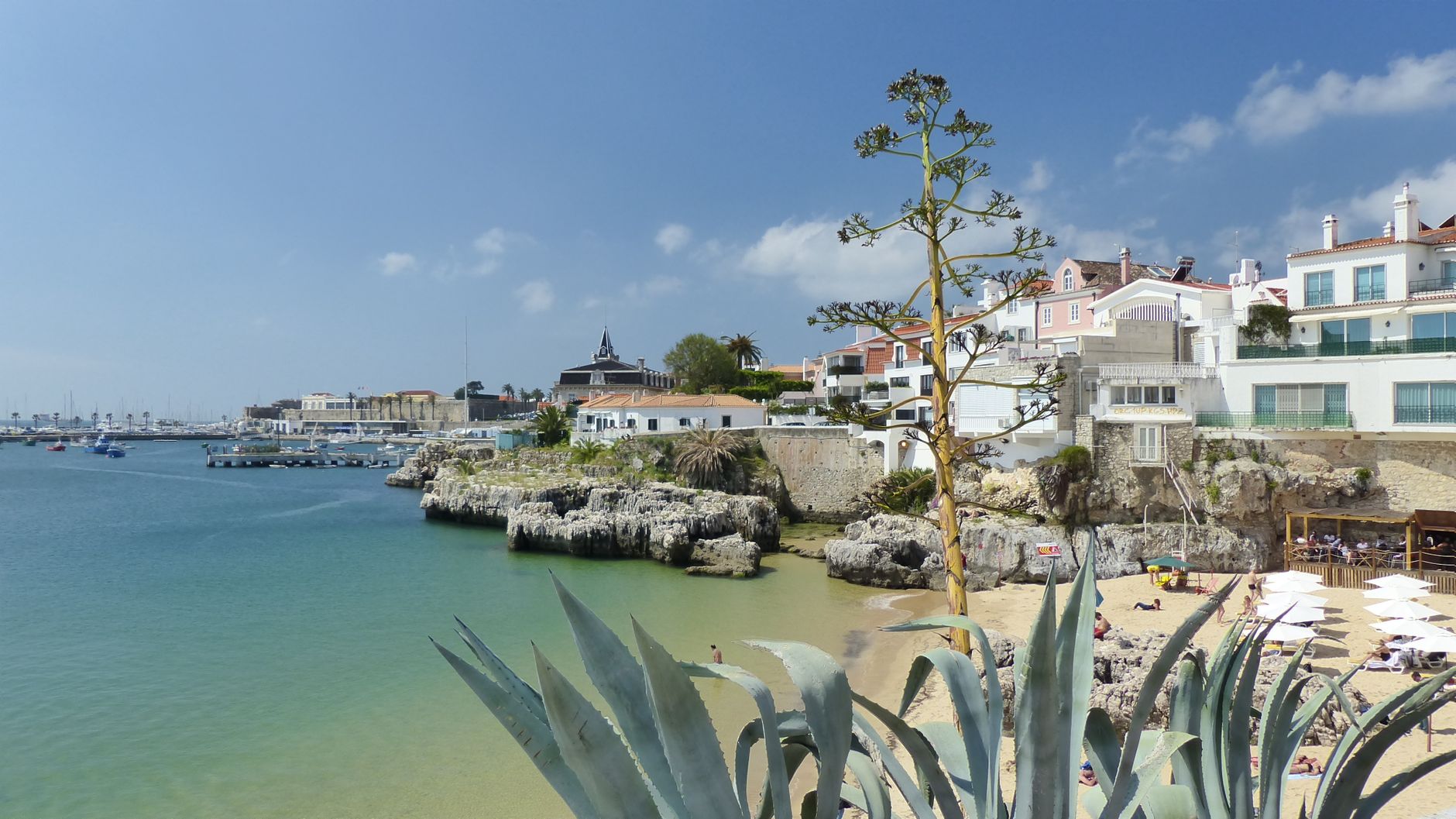 Beautiful seaside view of Cascais, Portugal, featuring beach and architecture on a sunny day.