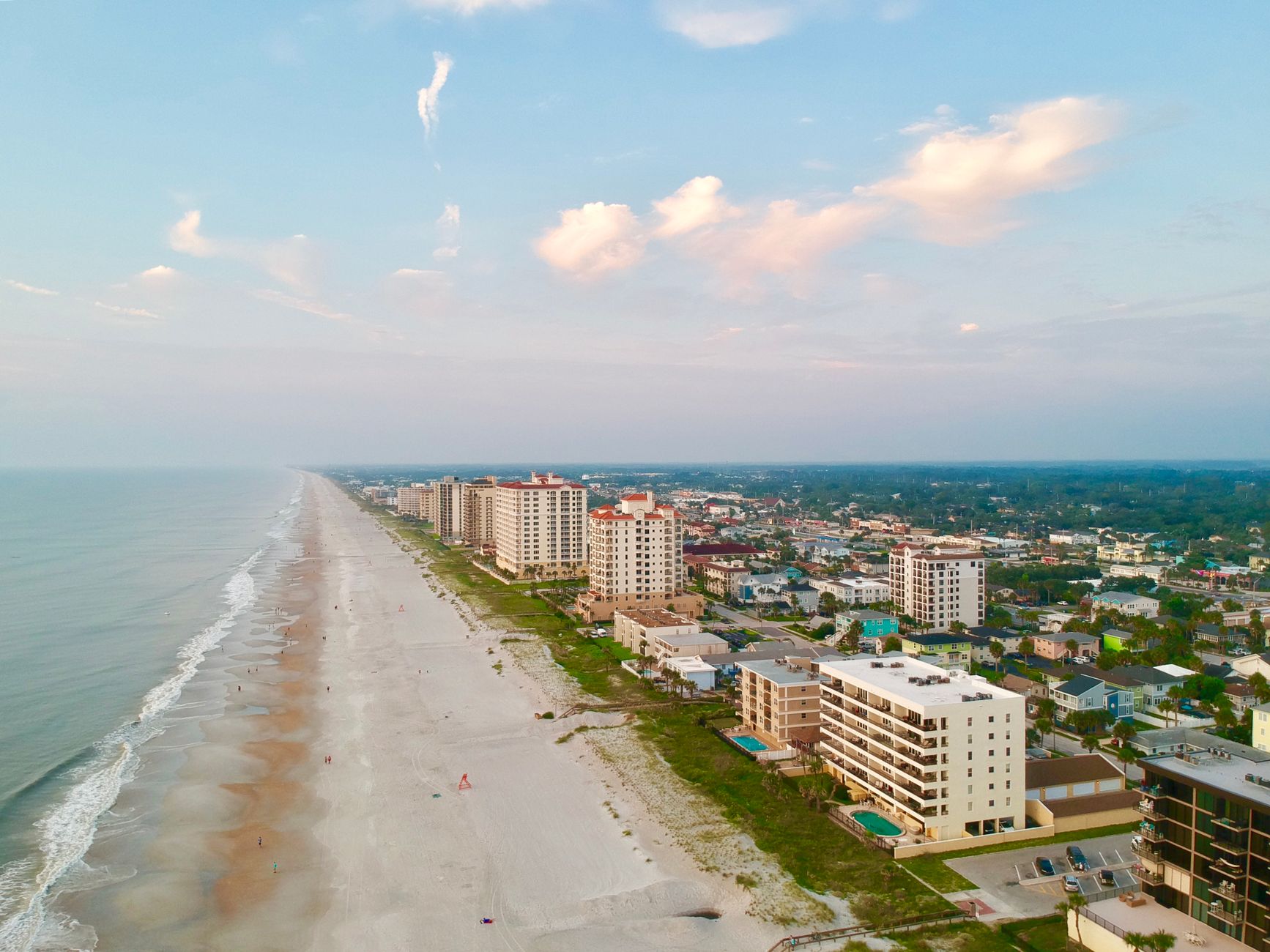 A stunning aerial view of Jacksonville Beach showcasing the coastline and cityscape under a bright sky.